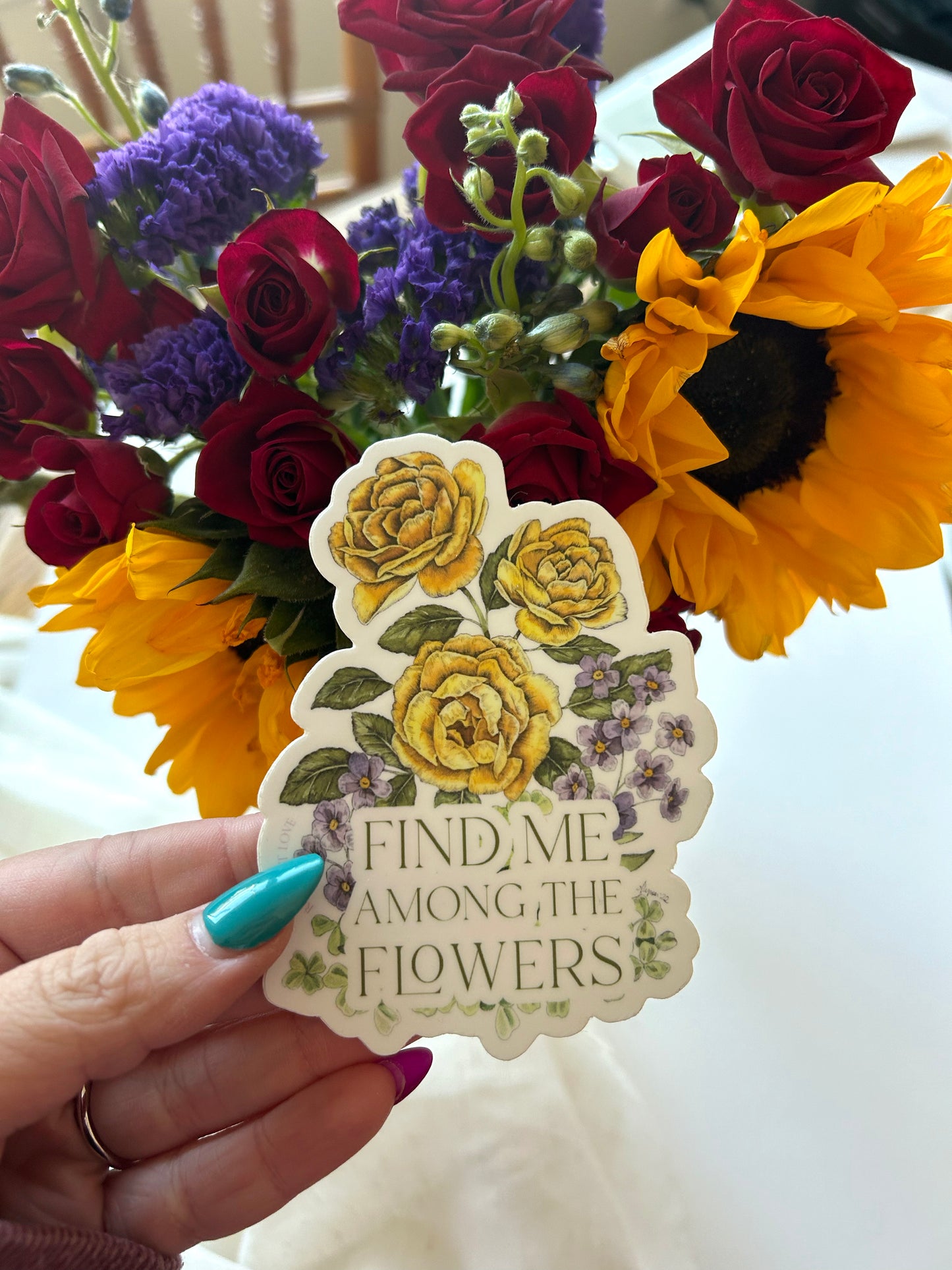 Multi-colored floral sticker that says "Find me among the flowers" by Rust Belt Love