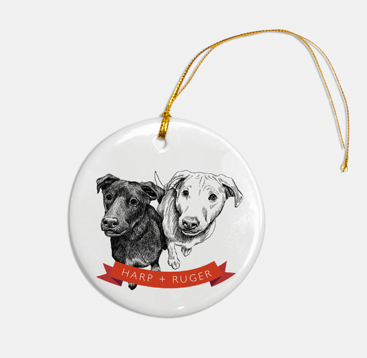 Circular glass ornament with a dog illustration with two dogs that reads "Harp + Ruger" by Rust Belt Love