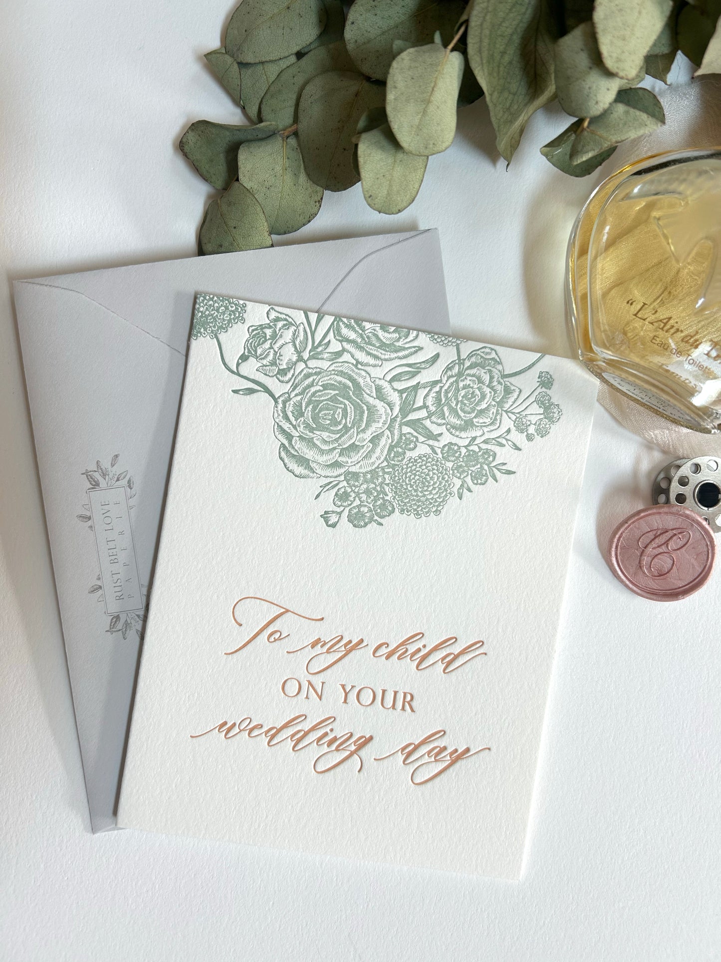 Style shot of letterpress wedding card with florals that reads "To my child on your wedding day" by Rust Belt Love