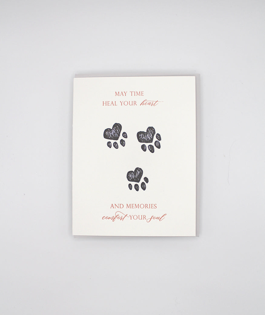 Letterpress sympathy card with black paw prints that reads "May time heal your heart and memories comfort your soul" by Rust Belt Love