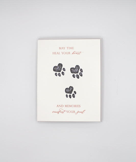 Letterpress sympathy card with black paw prints that reads "May time heal your heart and memories comfort your soul" by Rust Belt Love