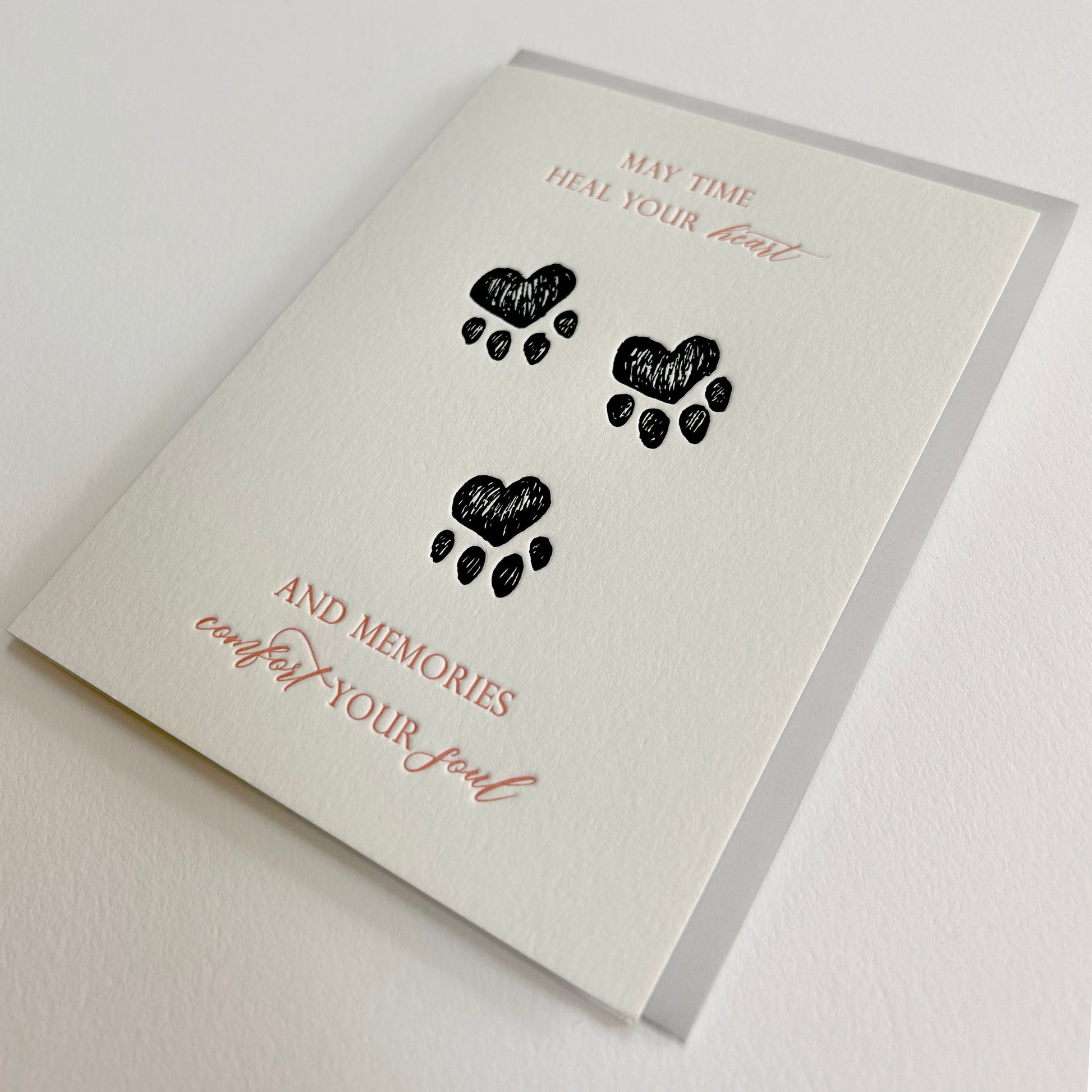 Letterpress sympathy card with black paw prints that reads "May time heal your heart and memories comfort your soul" by Rust Belt Love