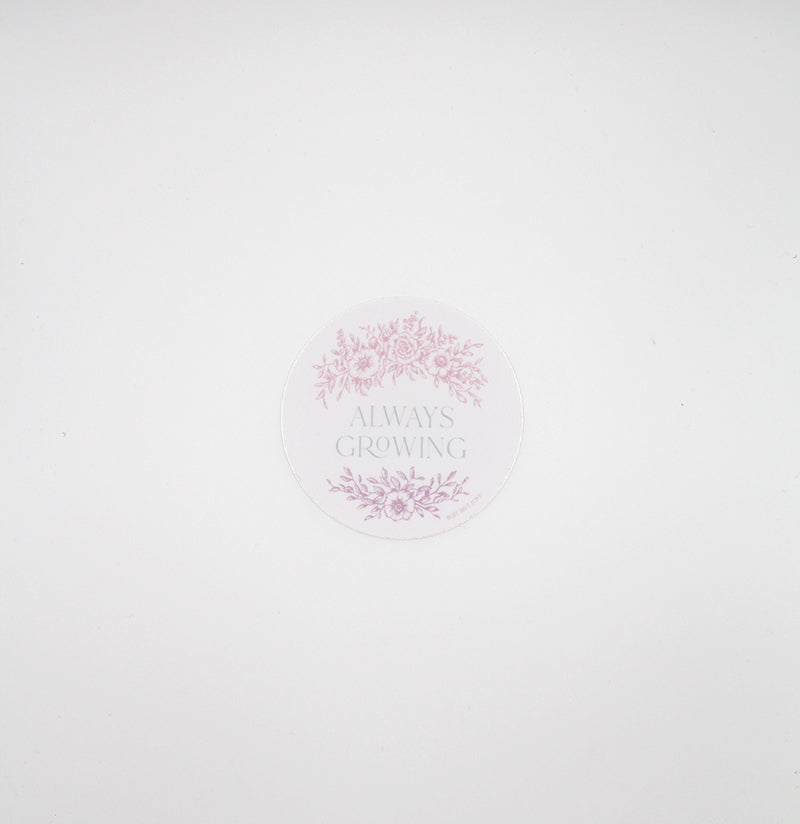 Circular pink sticker with florals that says "always growing" by Rust Belt Love