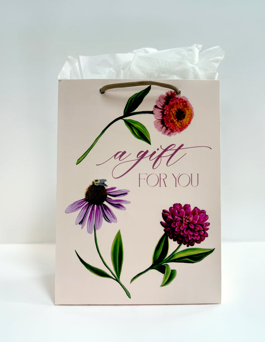 Standing up photo of pink gift bag with florals that reads "A gift for you" by Rust Belt Love