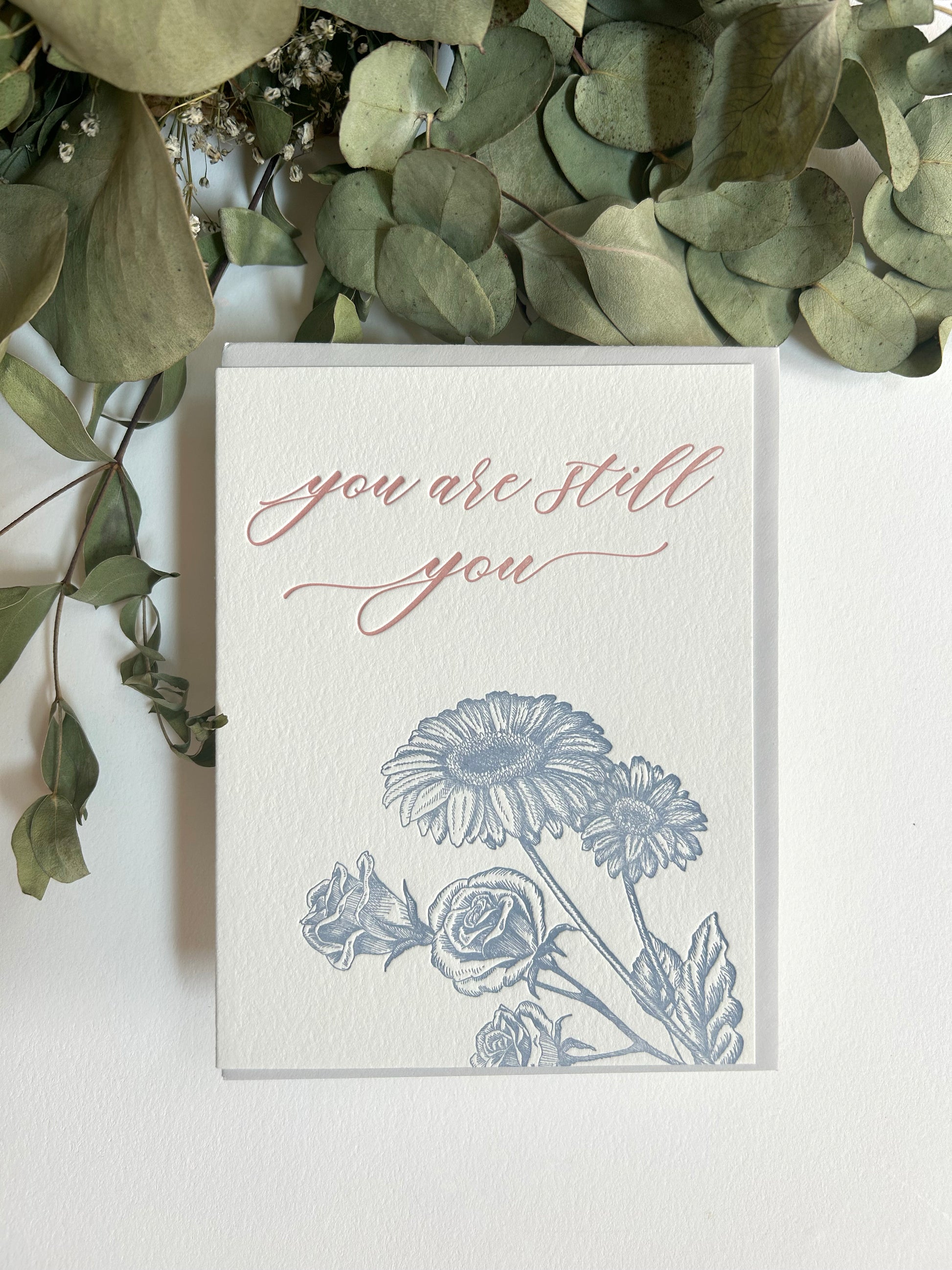 Style shot of letterpress encouragement card with florals that reads "you are still you" by Rust Belt Love