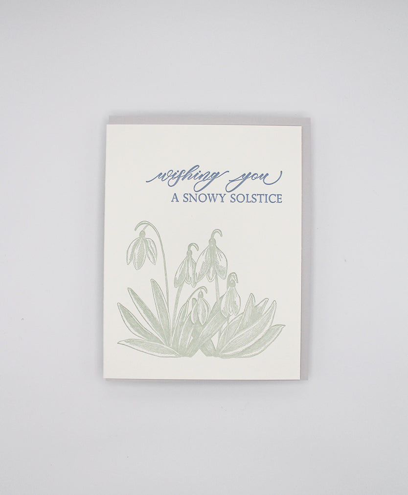 Letterpress holiday card with green florals that reads "wishing you a snowy solstice" by Rust Belt Love